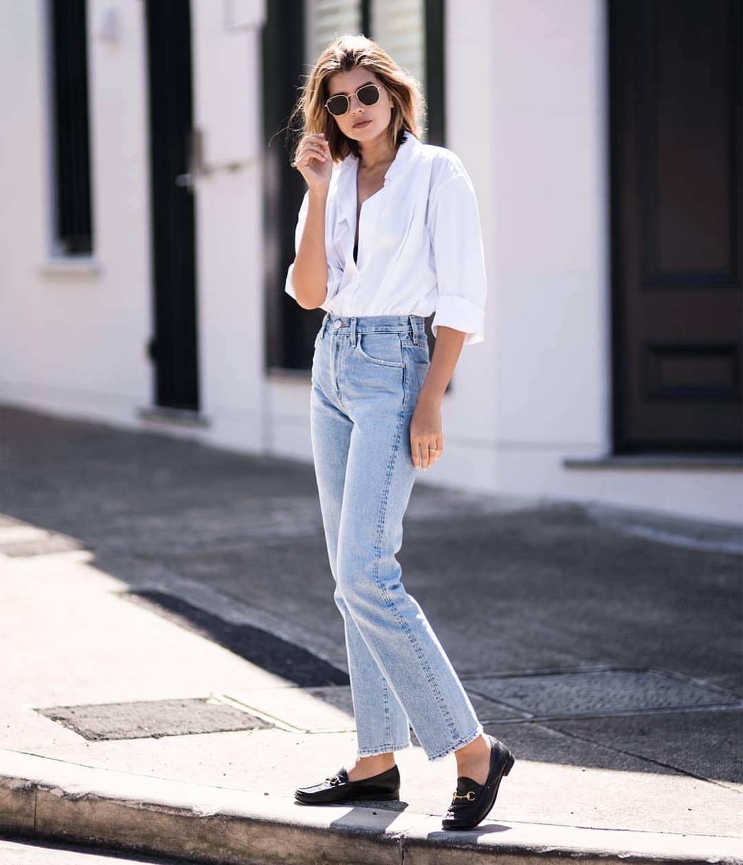 Os jeans mamãe combinam as tendências da moda feminina, camiseta branca, óculos escuros retrô, mocassins
