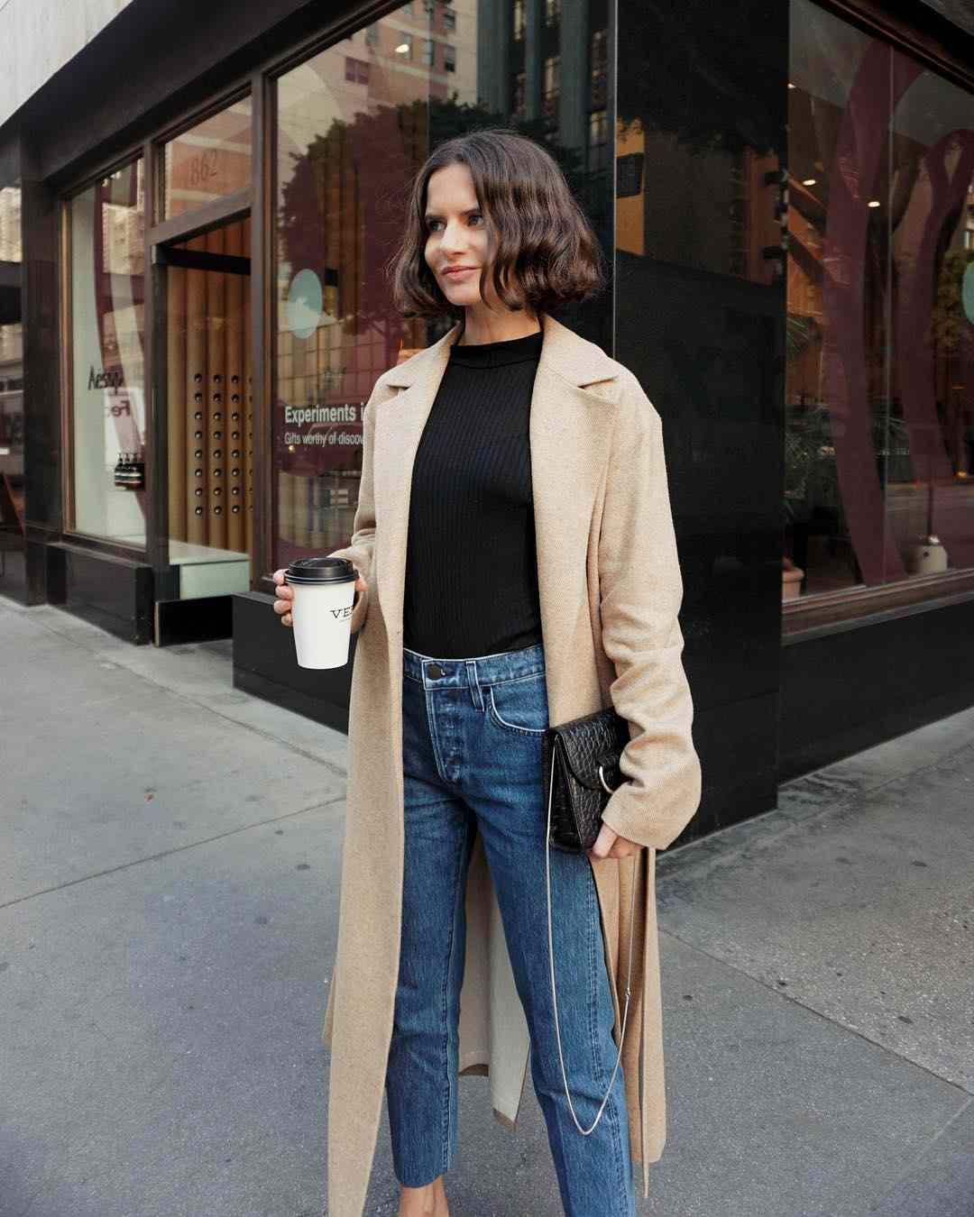 Os jeans mamãe combinam casaco de inverno com camisa preta com as últimas tendências da moda feminina 2019