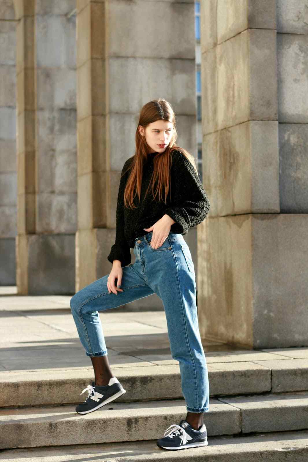 Os jeans da mamãe combinam as novas tendências da moda casual com tênis suéter preto