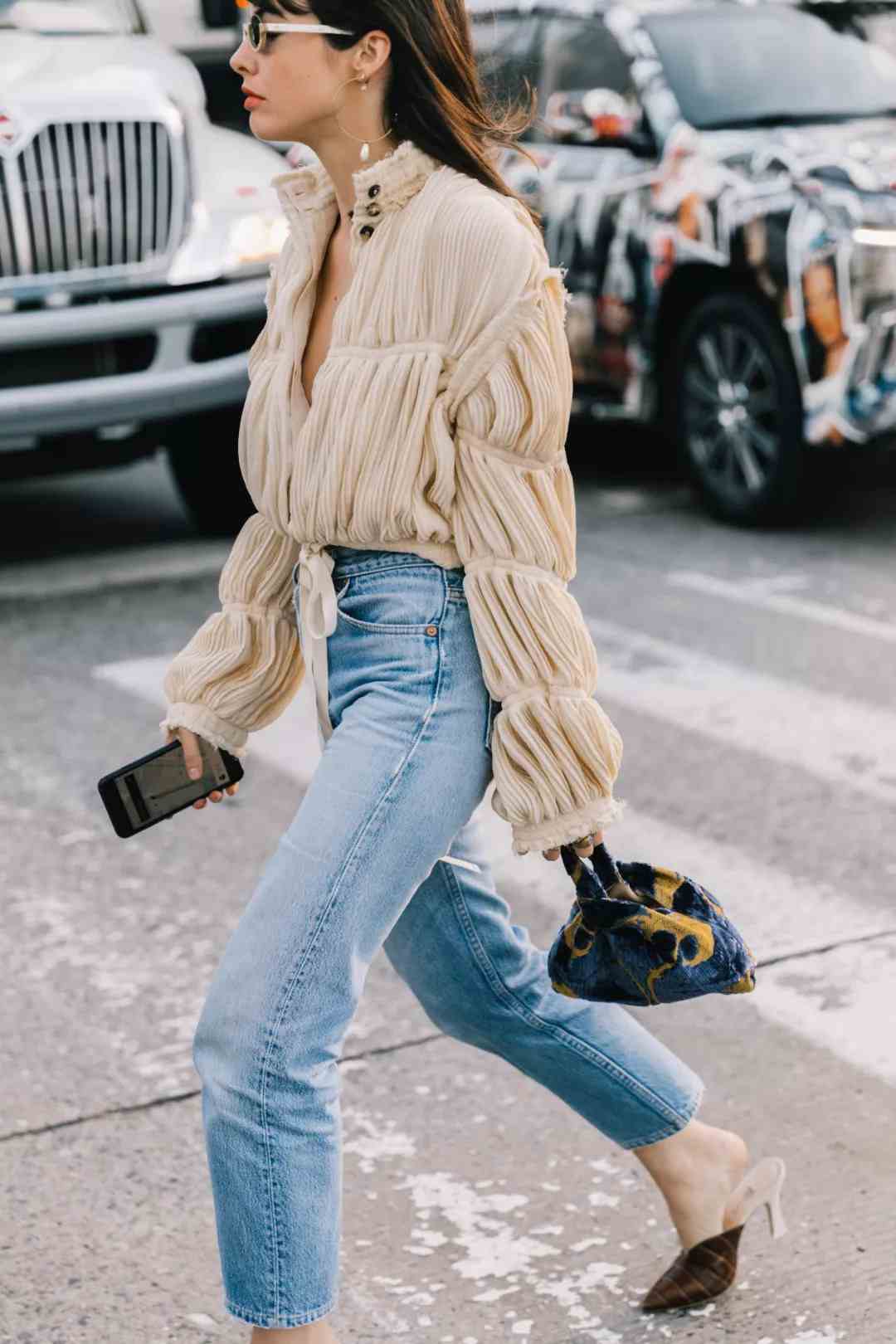 Os jeans da mamãe combinam as últimas tendências da moda em camisas de salto alto com babados de maneira elegante