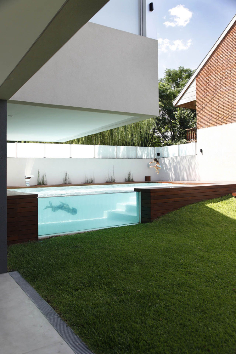 Piscina com área relvada envidraçada de design moderno