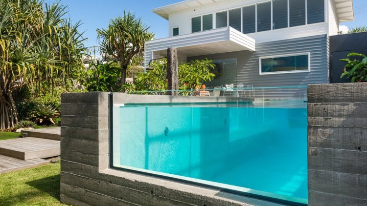 Piscina de concreto com parede de vidro de água azul