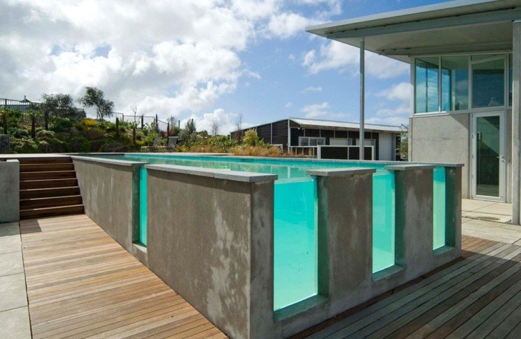 Piscina de concreto com combinação de vidro e terraço de madeira com contraste