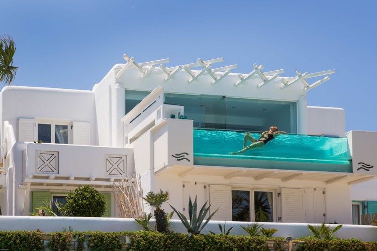 Varanda de vidro da piscina com fachada branca Hotel Mykonos