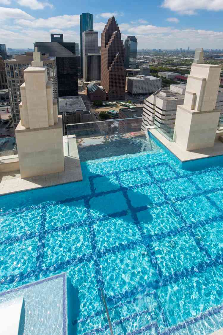 Arranha-céu com piso de vidro na cobertura da piscina com paredes de vidro em Houston