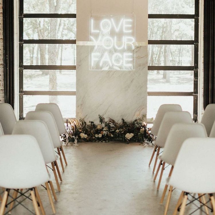 Moderno com um toque retrô - letras em néon como pano de fundo durante a cerimônia de casamento