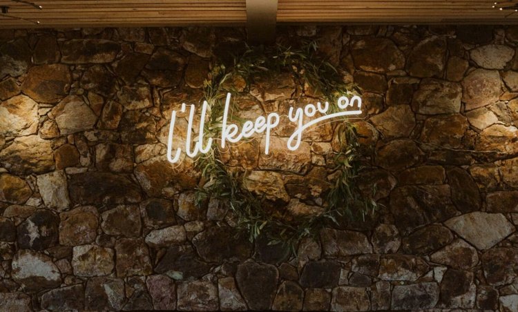 Letras em néon para a parede de pedra em um casamento rústico ou mediterrâneo
