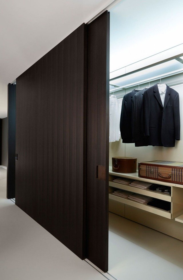 Armário walk-in com portas de correr em tom de madeira escura com design Decoma