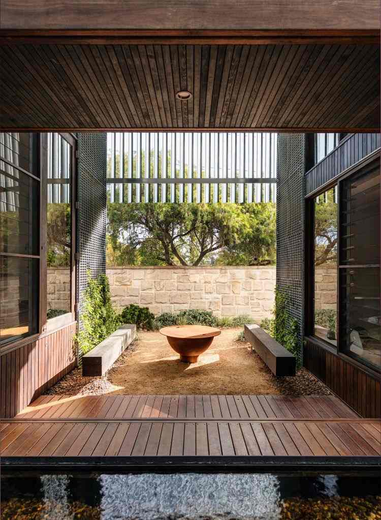 casa com anexo casa de donzela de ferro área de relaxamento bancos de madeira mesa pátio