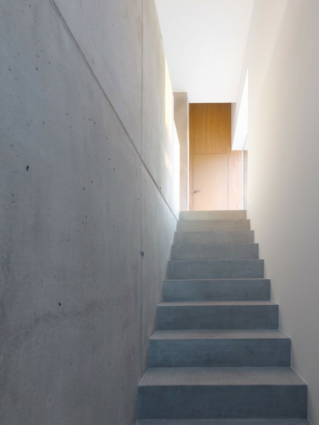segunda escada feita de concreto e paredes brancas de cimento