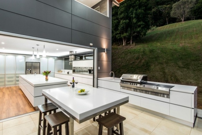 Cozinha de designer com paisagem de parede de vidro da ilha branca de corian