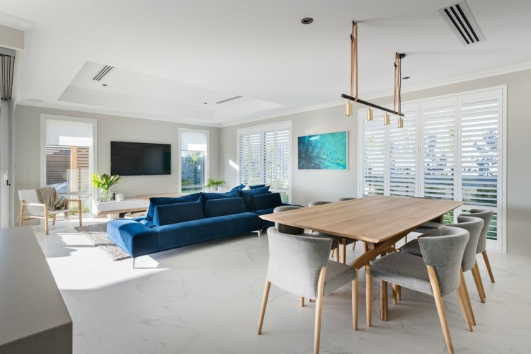 mesa de jantar cadeiras de tecido cobre sofá azul escuro residência moderna