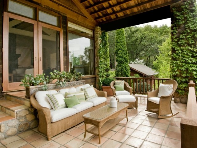 Ladrilhos de terracota cadeiras de vime, sofá, mesa, dossel de madeira