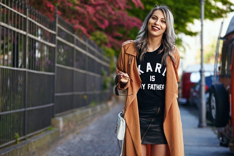 Gabardine marrom, camisa esparsa e saia de couro preta em um dia fresco de verão