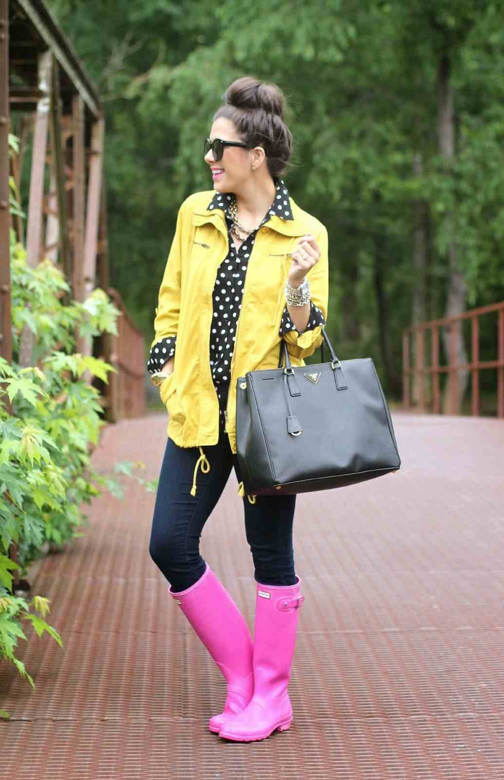 Jaqueta de chuva amarela, blusa pontilhada, botas de borracha rosa e jeans justos