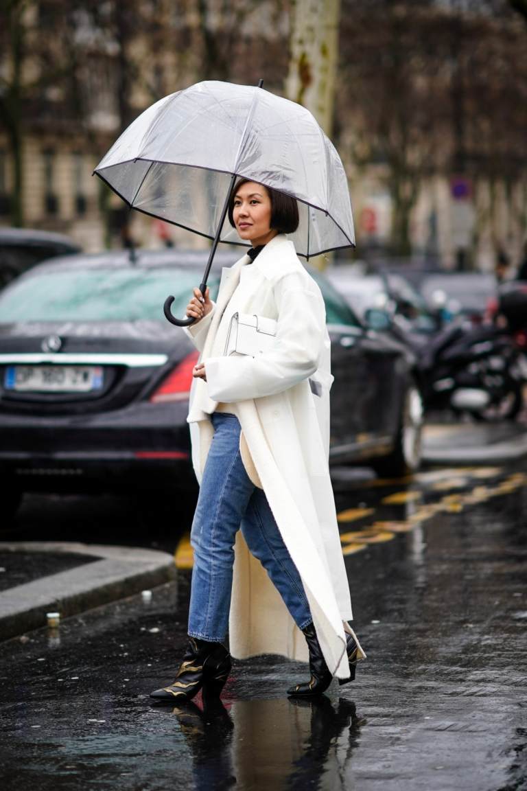 Use botas na chuva com jeans e um sobretudo branco