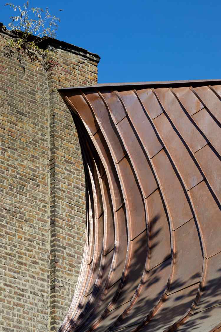 Placas de cobre no telhado interessante forma de funil contrastando com telhas de cobre