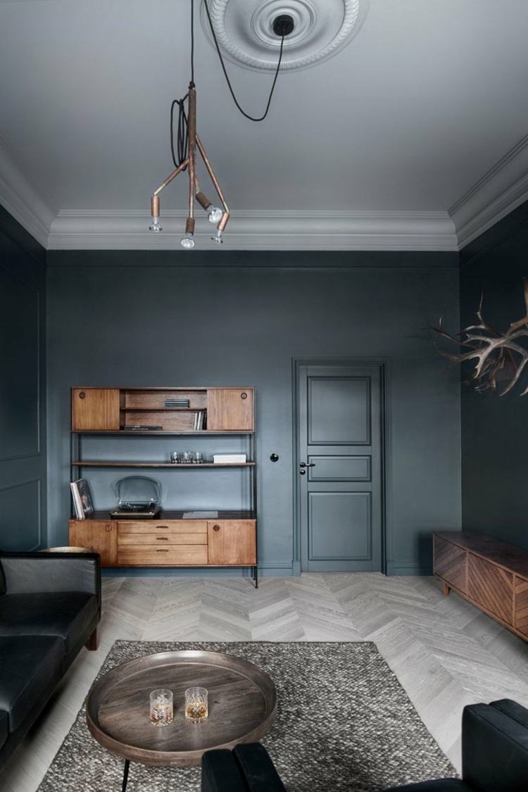 parede escura com móveis de madeira cinza lâmpada pendente da sala de estar
