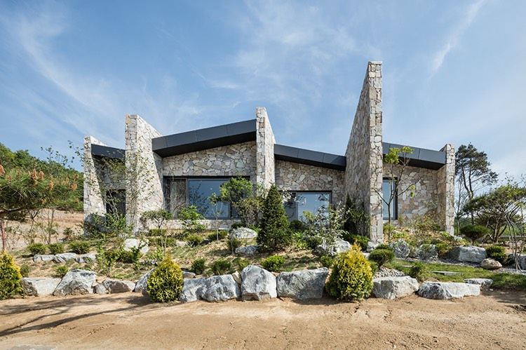 casa de pedra natural-arquitetura moderna-pedra-jardim na frente do telhado