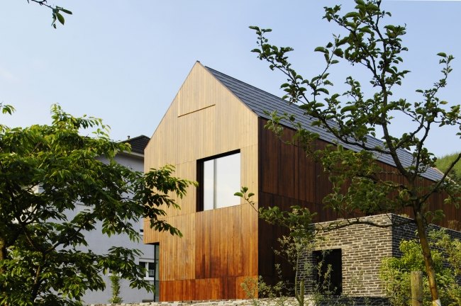 fachada de casa com eficiência energética revestimento de madeira pedra hemmes wirtz project