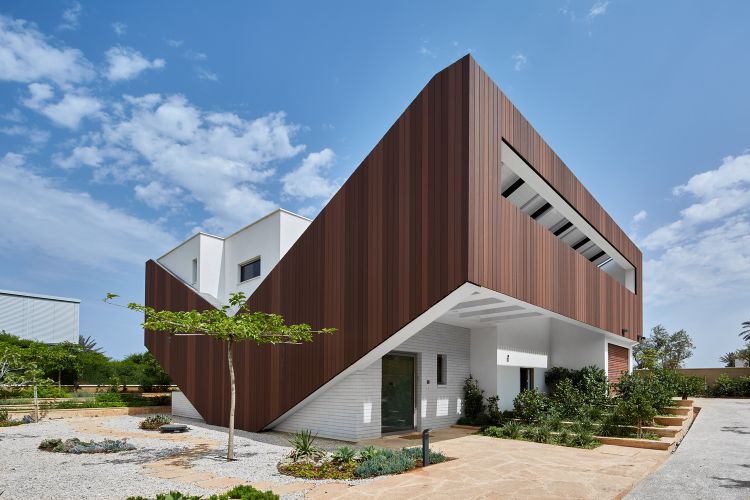 casa feita de material reciclado eco360 construção sustentável eficiência casa mais casa da energia mais casa da energia fachada tiras de madeira em forma de v vista lateral do jardim