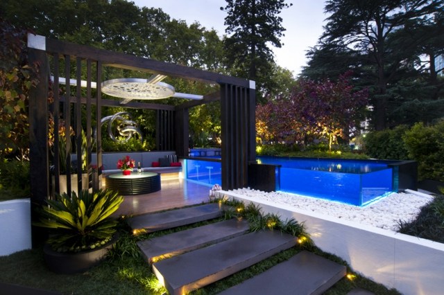 Jardim noturno grande piscina com área de estar com design agradável