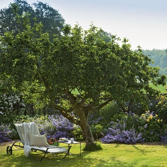 Lounge no jardim para relaxar em uma espreguiçadeira idílica à sombra de árvores