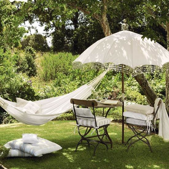 Área do lounge no jardim para relaxar com rede e proteção solar com guarda-sol no jardim