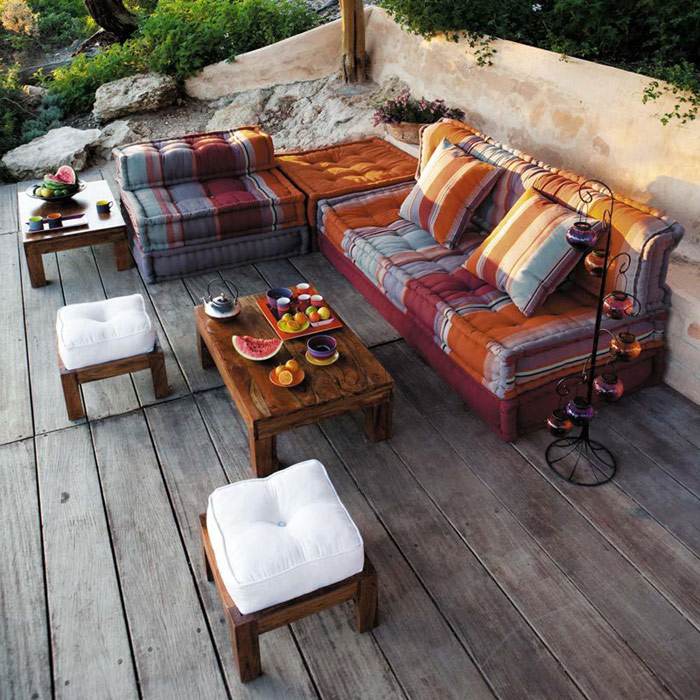 Área de lounge no jardim para relaxar almofadas em estilo étnico e lanternas