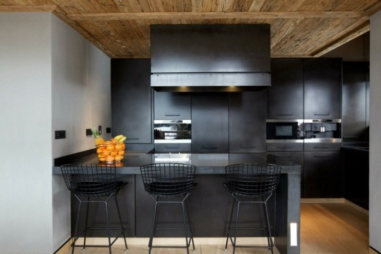cozinha de superfície preta mate balcão de metal cadeiras de bar branco pintura de parede teto de madeira