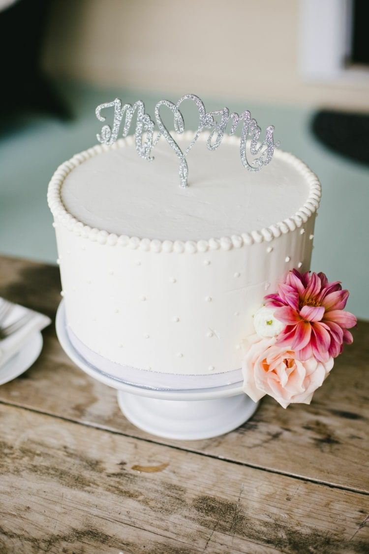 Crie bolos de casamento simples, de camada única e pequenos em branco liso e flores como destaque