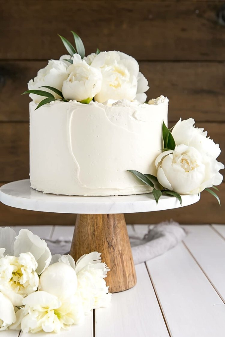 Bolo de limão de uma camada em branco e com peônias românticas