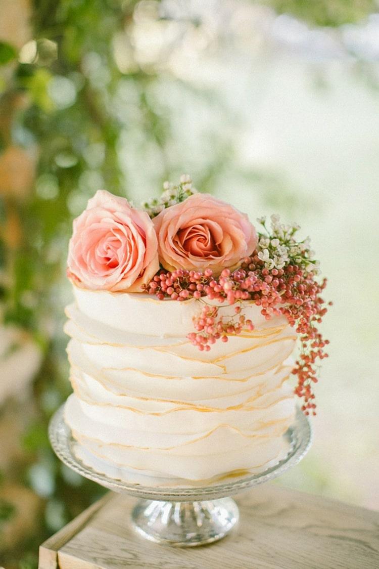 Bolo de casamento canelado decorado com flores rosa e frutas vermelhas para pequenos bolos de casamento simples em um nível