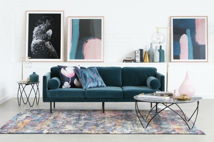 Mobília com um sofá de veludo, detalhes em azul petróleo e rosa