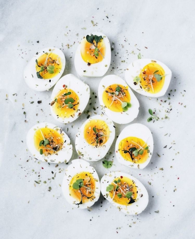 Divida pela metade alimentos que contenham proteínas, como ovos cozidos, e tempere-os como lanches saborosos entre as refeições