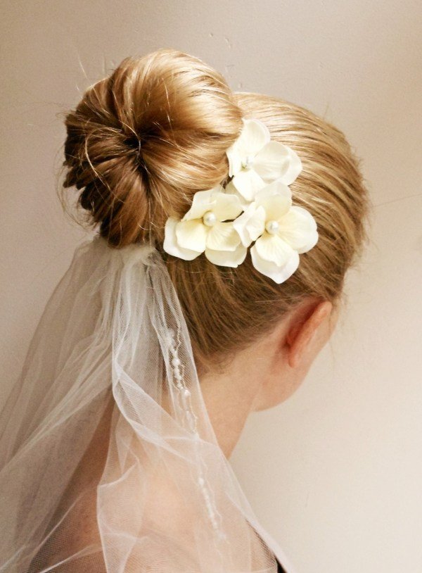 Penteado de casamento elegante, coque volumoso, presilhas de véu delicadas