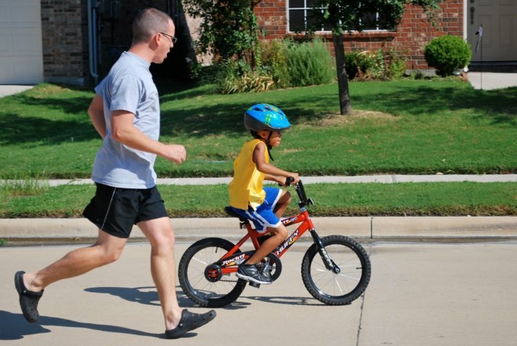 Aprenda a andar de bicicleta na segurança do caminho de pedestres do jardim da frente