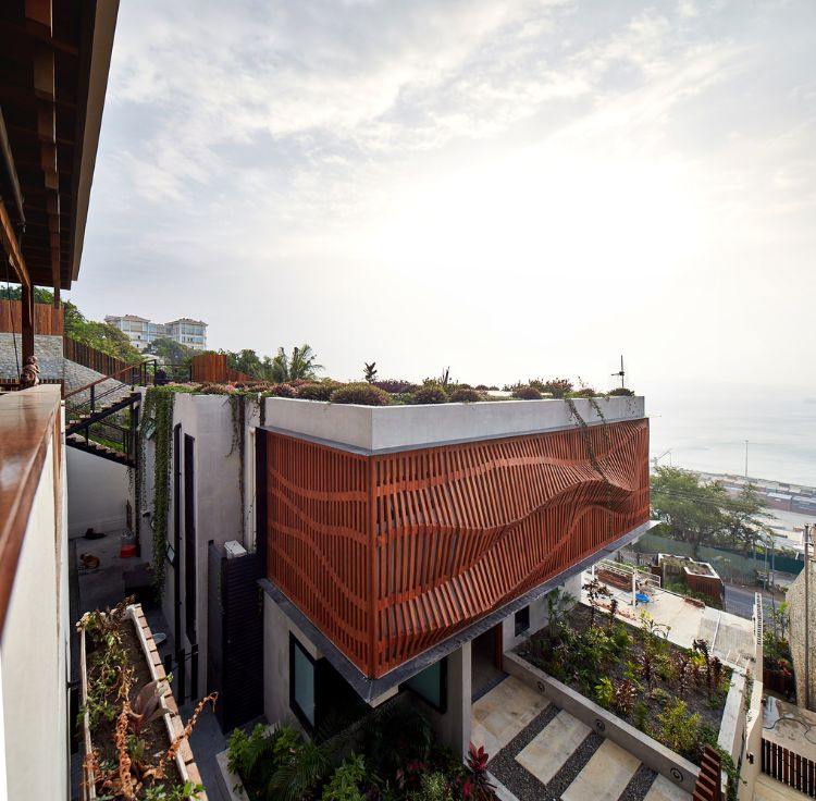 fachada revestida com madeira design moderno casa brise soleil proteção solar vista de pássaro telhado verde