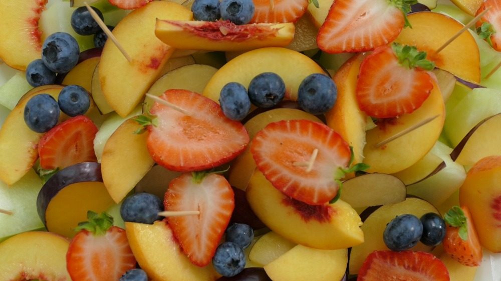 salada de frutas espetos de frutas ou espetos de frutas enquanto as crianças fazem petiscos com palitos de dente