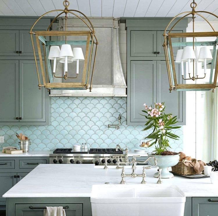 Parede traseira da cozinha em sutil azul claro em uma cozinha cinza-esverdeada com ilha de cozinha