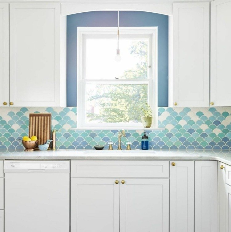 lindo espelho de azulejos em tons de azul e verde combinado com uma parede azul na cozinha