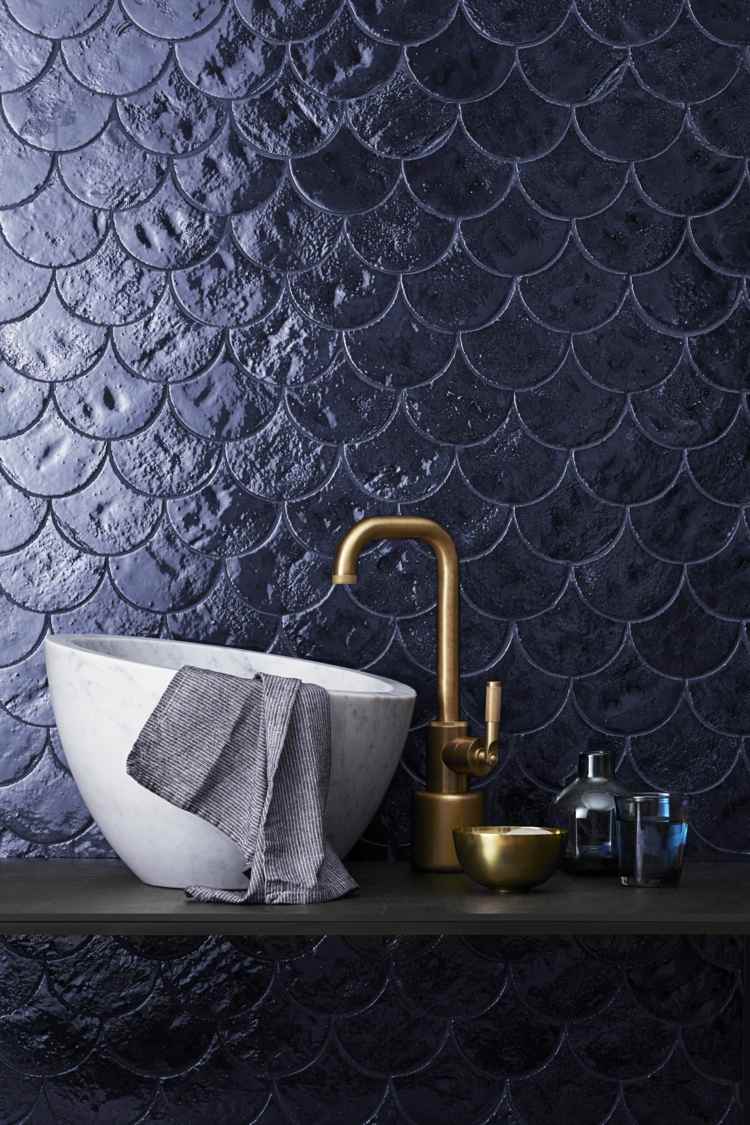 azulejos de escama de peixe azul escuro e pia no banheiro feito de pedra natural