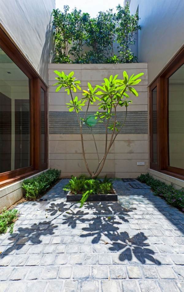 Casa estilo Bauhaus com piso de pedra no pátio interno