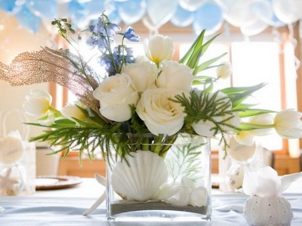 vaso de conchas de decoração marítima em cima da mesa com ambiente festivo