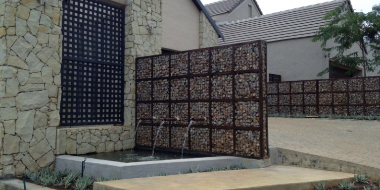 A água do jardim da parede de gabião apresenta ideias para fontes de jardim