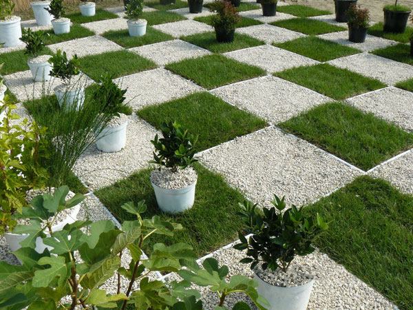 Jardim gramado quadrados seixos brancos e pretos vasos de flores