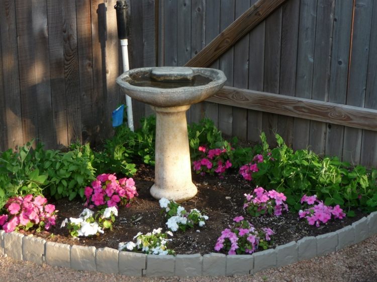 Canteiro de flores com fonte-jardim de canto
