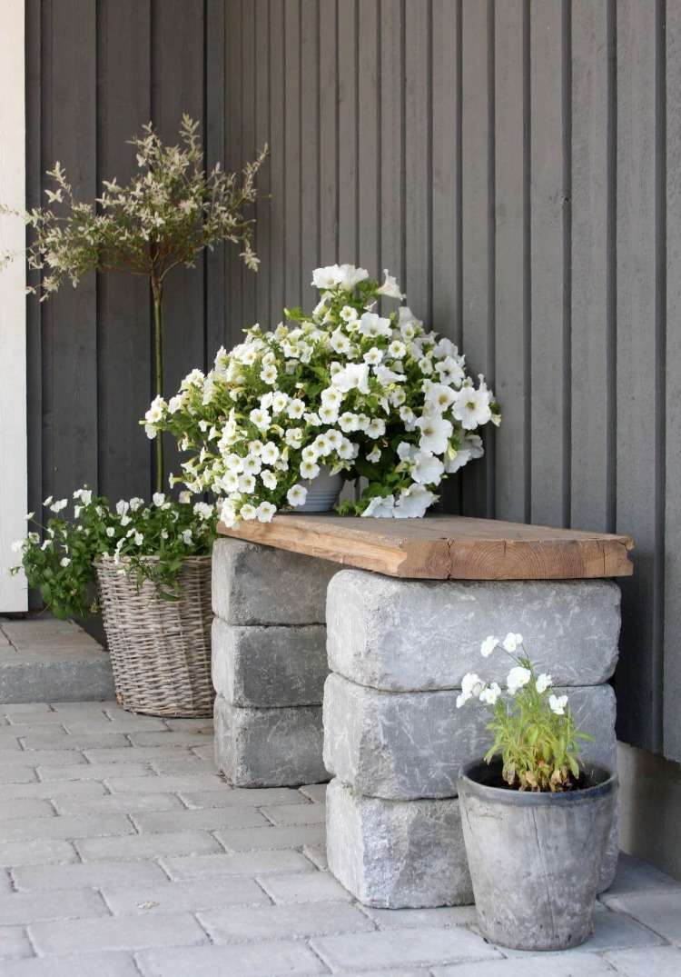 velhos blocos de concreto e madeira como materiais para um banco no jardim com flores