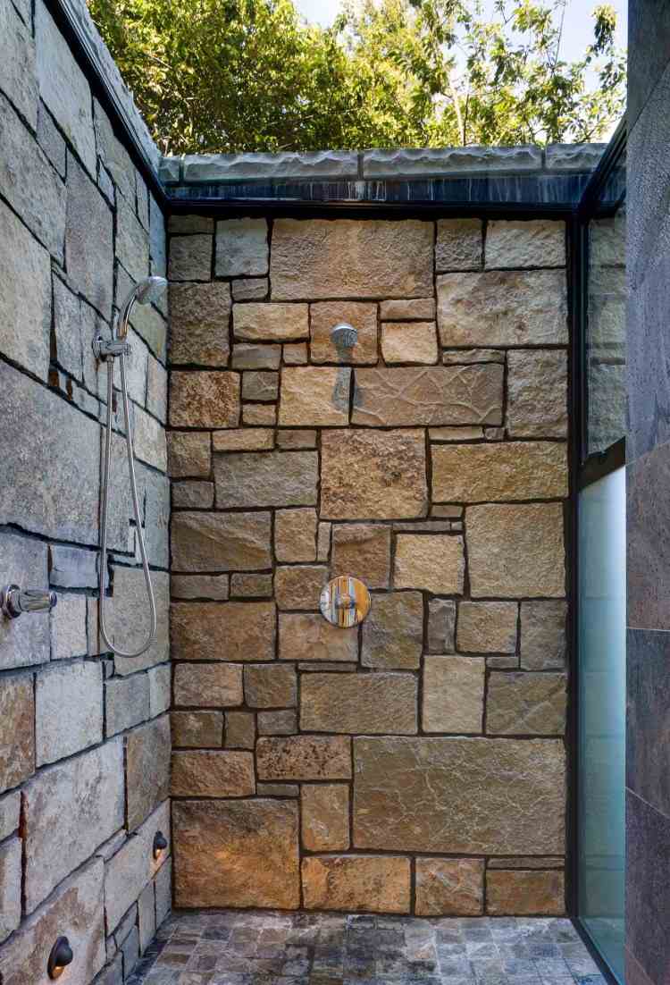 paredes do chuveiro do jardim e revestidas com lajes de pedra dispostas geometricamente