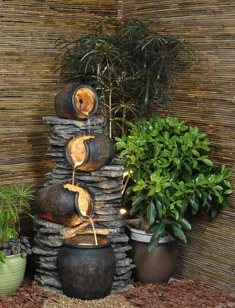 Crie um recurso de água de canto de jardim com plantas em vasos de iluminação LED